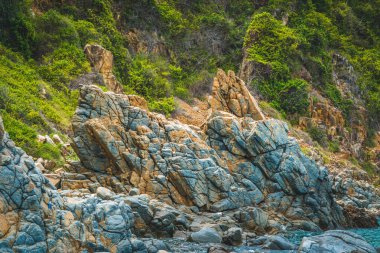 Güzellik manzarası, eski püskü deniz kayalıkları kümülüs bulutlu gökyüzü adası arka planı. Gri kahverengi taş desenli canlı renkli fotoğraf. Jeoloji kavramı, salgın üstüne turizm, doğada güç.