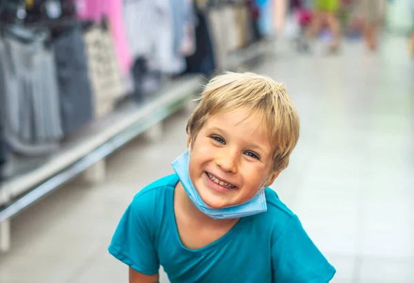 Bezár portré aranyos mosolygós kék szemű szeplős szőke fiú művészi arckifejezések, gesztusok viselő egészségügyi maszk bevásárló szupermarket. Új normál biztonsági egészségvédelmi kovid 19 karantén — Stock Fotó