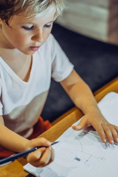 Potret anak laki-laki Preschool pirang memegang pena notebook terlihat serius tekun belajar menggambar corat-coret lucu, ekspresi wajah gerakan. Pendidikan perilaku anak, konsep sekolah rumah — Stok Foto