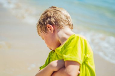 Kötü, mutsuz, üzgün, üzgün, düşünceli, küçük sarışın çocuk duyguları. Kapalı ellerle dönüp arkana bak. Sorunlu çocukluk, aile ilişkileri çocuk psikolojisi konsepti