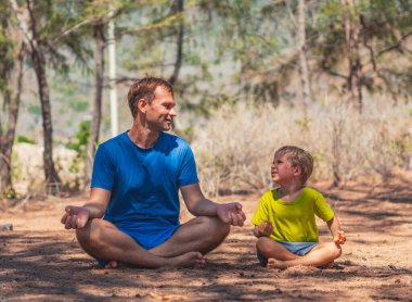 Baba orman parkında yoga pozu veriyor. Temiz hava alıyor. Oğlu tekrar ediyor. Babacığın dünyaya bakış açısı üzerinde etkisi var. Babalık ilişkisi. Çocuklar çocukluk davranışlarını taklit eder.