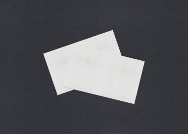 Gri desenli kağıt arkaplanda boş beyaz kartvizit düzenleme yığınları.