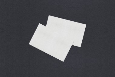 Gri desenli kağıt arkaplanda boş beyaz kartvizit düzenleme yığınları.