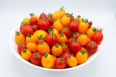 Beyaz arka planda parlak olgun ve sulu sarı ve kırmızı domateslerin karışımı.