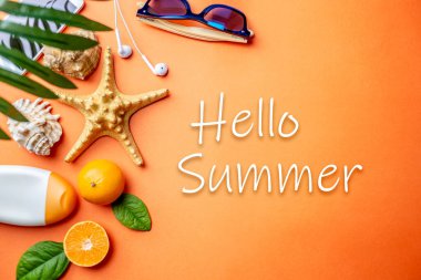 Plaj tatili için aksesuarlar. Turuncu arka planda yaza merhaba mesajı. Denize seyahat ve tatil kavramı. Üst görünüm