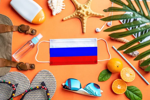 在带着俄罗斯国旗的保护罩周围的海滩度假配件 大流行病期间海上休闲的概念 顶部视图 — 图库照片