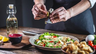 Şef peyniri iştah açıcı taze bir salata olarak rendeliyor. Lezzetli yemek yapma kavramı Sezar