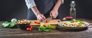 Şef domatesleri kesiyor. Taze lezzetli bir salata hazırlama süreci kavramı