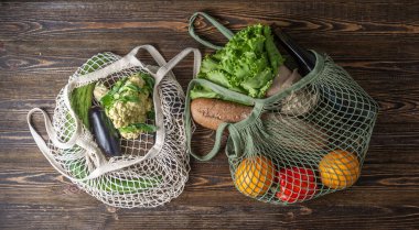 Tahta bir masanın üzerinde ip torbası. Çevre dostu davranış anlayışı, yeniden kullanılabilir çantaların kullanımı ve çevre bakımı. Üst görünüm