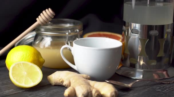 Kişi, zencefil, limon ve ballı bir bardak sıcak vitamin çayı koyuyor. Soğuk günlerde yararlı ve lezzetli çay kavramı ya da grip. — Stok video