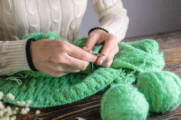 Woman is knitting a cozy warm sweater with needles. Concept of hobbies and creating handmade things.