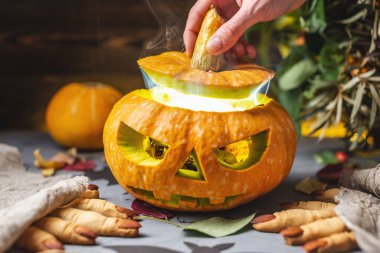 El balkabağını yüzüyle açıyor ve içinden duman çıkıyor. Cadılar Bayramı 'nı ve gizemli bir atmosferi kutluyoruz..