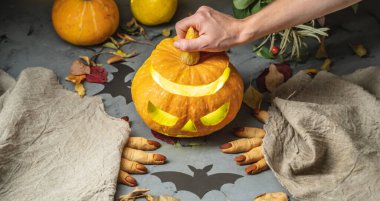 El, yüzü kesilmiş bir şekilde balkabağını açıyor. Cadılar Bayramı 'nı ve gizemli ve korkutucu bir atmosferi kutluyoruz..