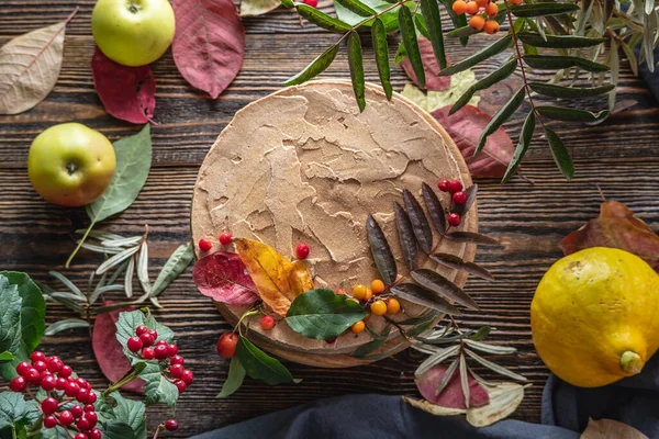 秋の葉や果実で飾られた茶色のムースケーキ 木製の背景 秋の気分と雰囲気の概念 — ストック写真