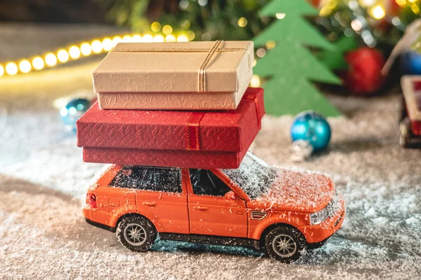 Een Oranje Speelgoedauto Rijdt Langs Een Besneeuwde Weg Tegen Achtergrond — Stockfoto