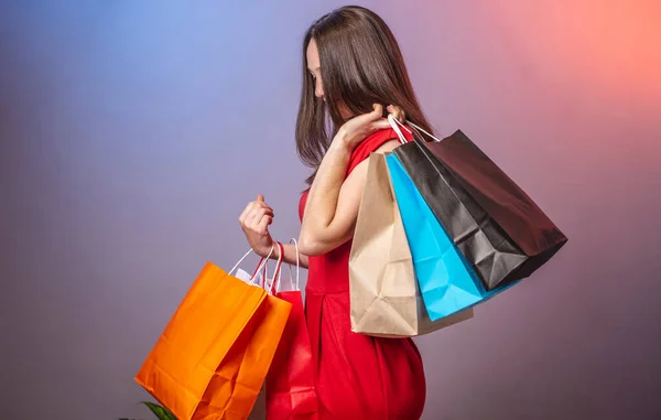 Young Woman Red Dress Holding Lot Multicolored Paper Bags Purchases — Stock Photo, Image