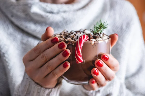 暖かい居心地の良いセーターの女性は マシュマロ 赤いキャンディー クリスマスツリーの枝で飾られたホットチョコレートのカップを持っています お祭り気分のコンセプトと熱い飲み物を楽しむ — ストック写真