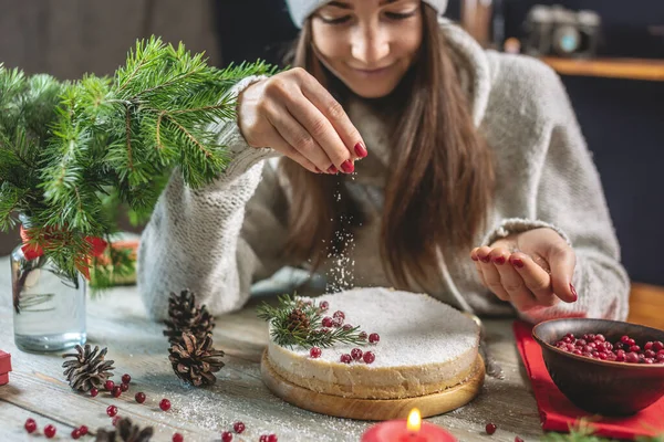 女性が白いムースのお祝いケーキを飾り 雪を模したココナッツフレークで振りかける クリスマスと新年の概念 — ストック写真