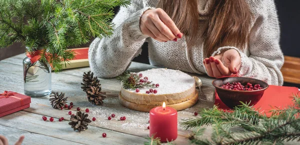 女性が白いムースのお祝いケーキを飾り 雪を模したココナッツフレークで振りかける クリスマスと新年の概念 — ストック写真