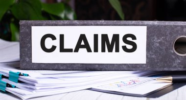 CLAIMS, belgelerin yanındaki gri bir klasöre yazılmıştır. İş konsepti
