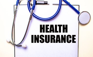 Sağlık Bakanlığı steteskopun yanındaki beyaz bir kağıt parçasına yazılmış. Tıbbi ve sigorta konsepti