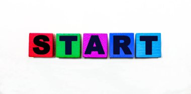 START kelimesi açık arkaplanda çok renkli tahta küplere yazılmıştır..