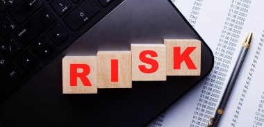 RISK kelimesi kalemin yanındaki klavyede tahta küplere kırmızıyla yazılır..