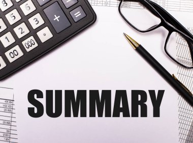 Sözcük siyah çerçeveli gözlük, kalem ve hesap makinesi arasında beyaz bir sayfaya yazılır.