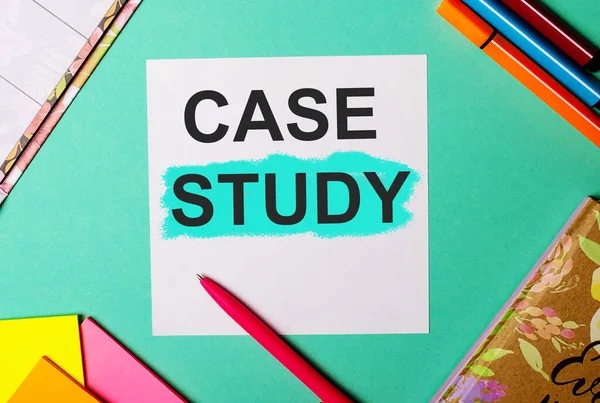 CASE STUDY written on a turquoise background near bright stickers, notepads and markers