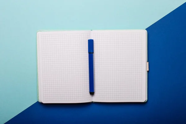 薄い青と青の背景に 青いマーカーと開いた空白のノートブック スペースのコピー — ストック写真