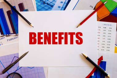 BENEFITS kelimesi renkli grafikler, kalemler ve kalemlerin yanında beyaz bir arkaplanda yazılmıştır. İş konsepti