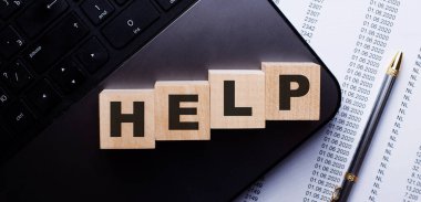 HELP kelimesi kalemin yanındaki klavyede tahta küplere kırmızı ile yazılır..