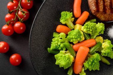 Siyah saç yakın çekim üzerinde bebek havuç ile romanesco brokoli