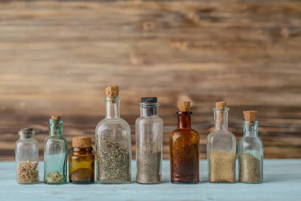 Ahşap arka plan üzerinde çeşniler ile küçük eski cam kavanoz