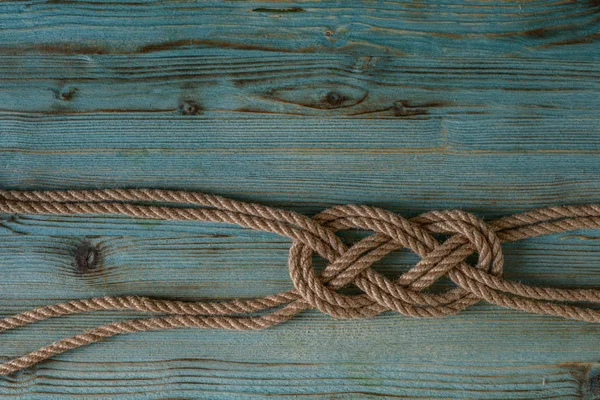 Ahşap mavi eski püskü bir arka planda güzel bir denizcilik düğümü.