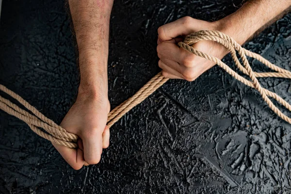 symbolism of human connection through hands and rope