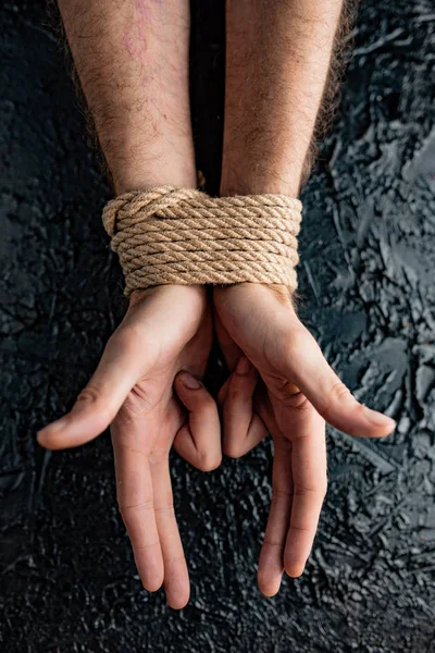 symbolism of human connection through hands and rope