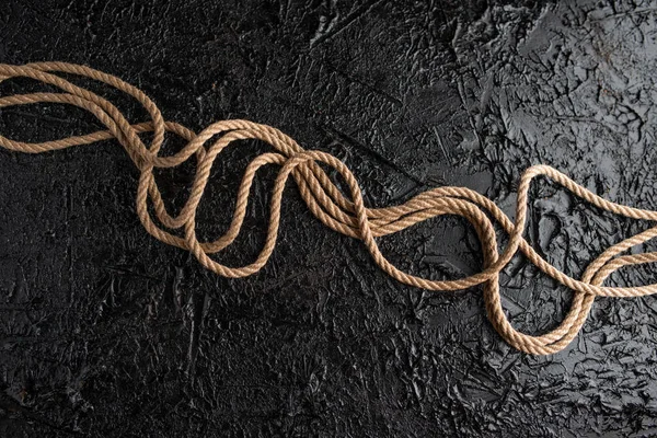 siyah bir masanın üzerinde yatan jüt halat