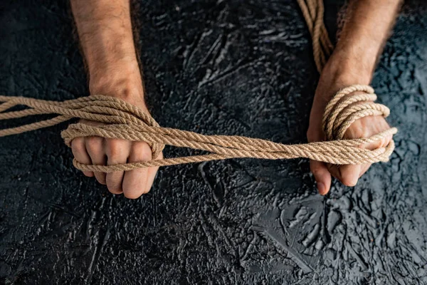 symbolism of human connection through hands and rope