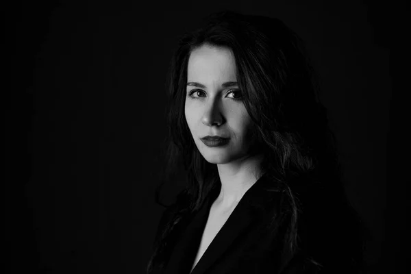 Portrait of a girl in black and white on black background in noir style