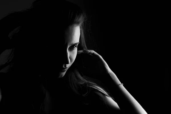 Portrait of a girl in black and white on black background in noir style