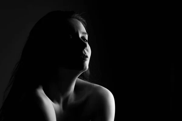 Portrait of a girl in black and white on black background in noir style