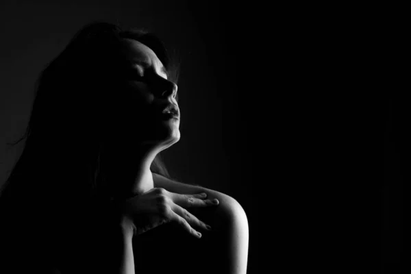 Portrait of a girl in black and white on black background in noir style