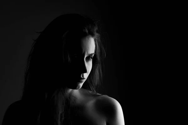 Portrait of a girl in black and white on black background in noir style