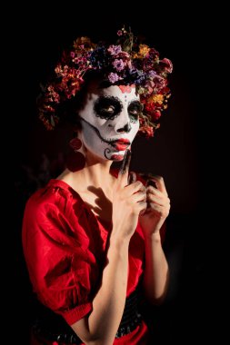 Tatil da de los muertos için kafasına halloween kafatası ve çiçekler için makyaj ile bir kızın portresi