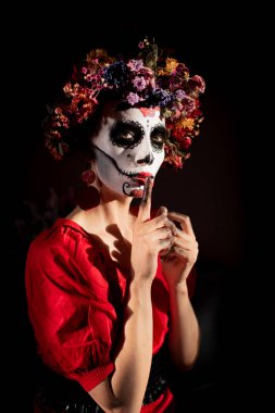 Tatil da de los muertos için kafasına halloween kafatası ve çiçekler için makyaj ile bir kızın portresi