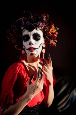 Tatil da de los muertos için kafasına halloween kafatası ve çiçekler için makyaj ile bir kızın portresi