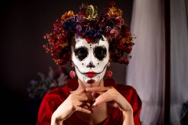 Tatil da de los muertos için kafasına halloween kafatası ve çiçekler için makyaj ile bir kızın portresi