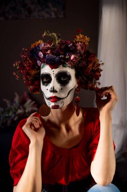 Tatil da de los muertos için kafasına halloween kafatası ve çiçekler için makyaj ile bir kızın portresi