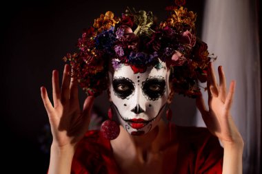 Tatil da de los muertos için kafasına halloween kafatası ve çiçekler için makyaj ile bir kızın portresi